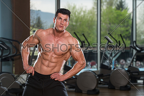 Young Man Stretching Before Exercising In Fitness Center Healthy Lifestyle Concept