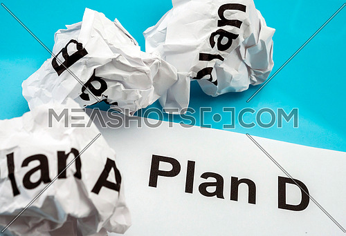 Crumpled paper Plan A B C and clean sheet Plan D isolated on blue background , conceptual image