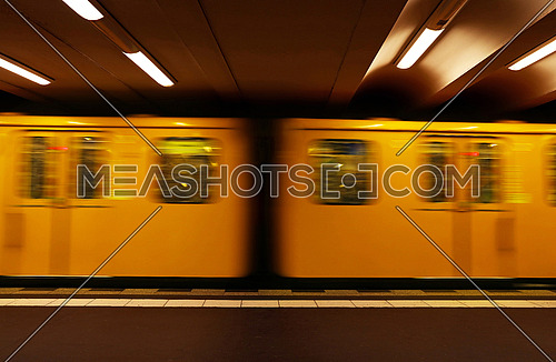 Close up yellow metro underground train carriage in motion, side view