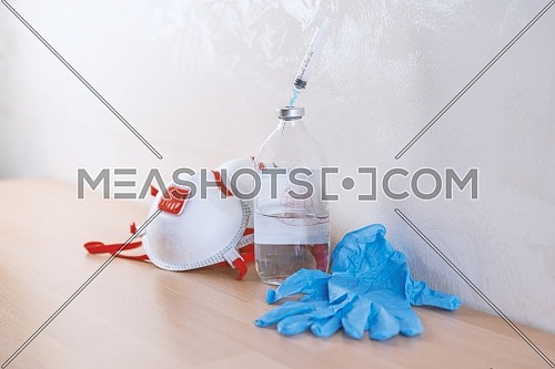 Face Mask,blue medical gloves,syringe inside physiological water ,accessories for protection against Covid-19 or other viruses and infections.concept Coronavirus Vaccine Research