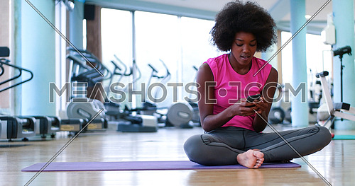 young Athletic healthy black woman resting during workout in gym