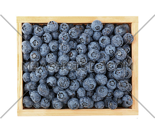 Close up wooden crate box of fresh washed blueberry berries with water drops, elevated top view, directly above