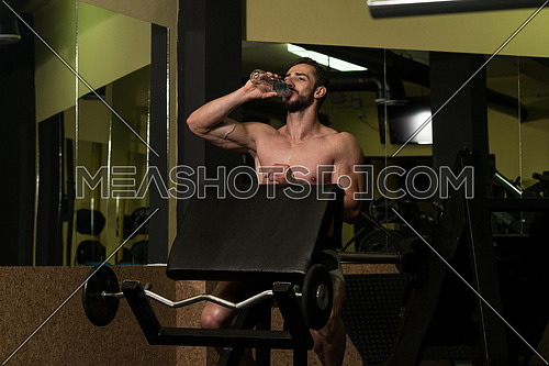 Muscular Man Resting After Exercise And Drinking Water