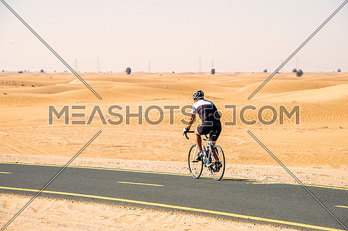 cyclist cycling on a track in the desert