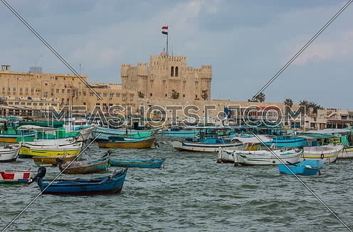 Fixed Long Shot outside Citadel of Qaitbay shows fishing boats at day