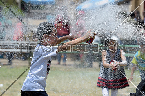 A child spraying white foam on other kids during eid al fitr celebration on 7 july 2016