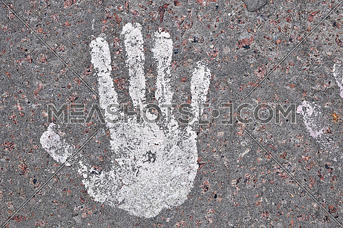 Close up human hand or palm shaped paint print on grunge concrete background