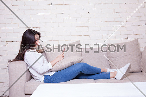 A girl sitting on a couch holding her mobile