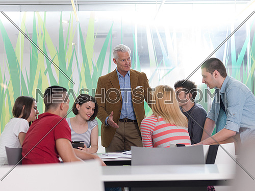 group of students study with professor in modern school classroom