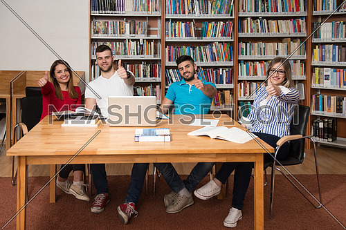 Portrait Of A Group Of Students Showing Thumbs Up In College Library - Shallow Depth Of Field