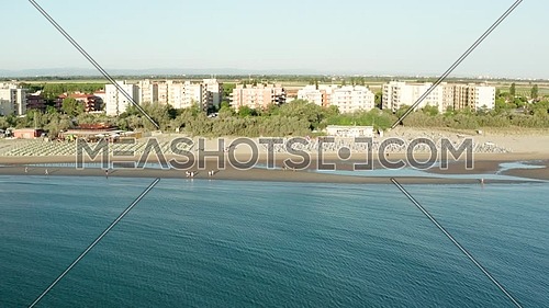 Aerial shot of sandy beach with umbrellas and gazebos.Summer vacation concept.Lido Adriano town,Adriatic coast, Emilia Romagna,Italy.
