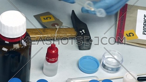 Police scientist analyzes blood from crime scene at laboratory criminologist