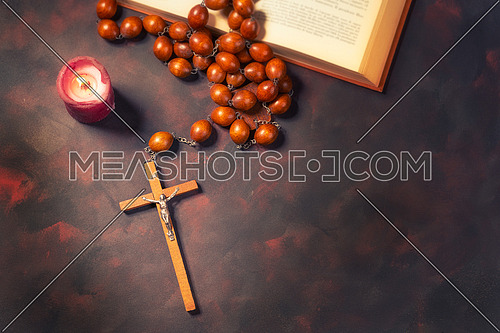 Big wooden Rosary beads and crucifix cross with jesus,red candle and bible book,spiritual atmosphere ,religion concept.
