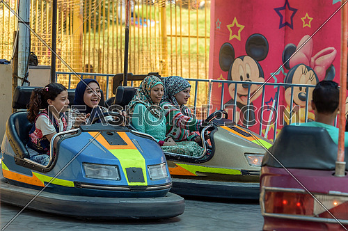Egyptian Girls enjoy riding an electric car in an amusement park during eid celebrations