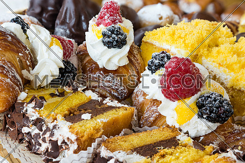 In the pictured typical italian pastries with cream,choccolate,rasperry and blackberry with various forms.