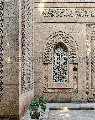 Arched window with grid of ornate marble geometric pattern in the bricks stone wall of the mosque of The Manial Palace of Prince Mohammed Ali Tewfik, Cairo, Egypt