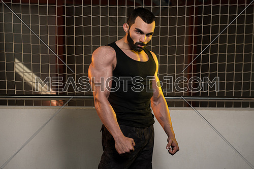 Portrait Of A Young Fit Man Showing His Well Trained Body In Tank - Muscular Athletic Bodybuilder Fitness Model Posing After Exercises