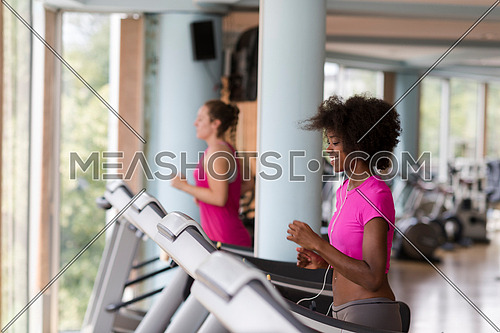 young people exercisinng a cardio on treadmill running chine in modern gym
