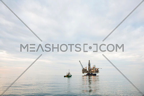 Oil rig being tugged in the sea