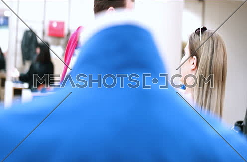 young man with woman choosing clothes in mall or clothing store 