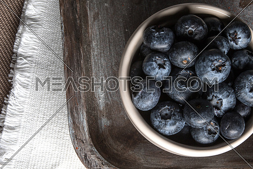 A bowl of blueberries with white burlap