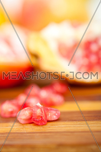 fresh pomegranate fruit over wood cutting board