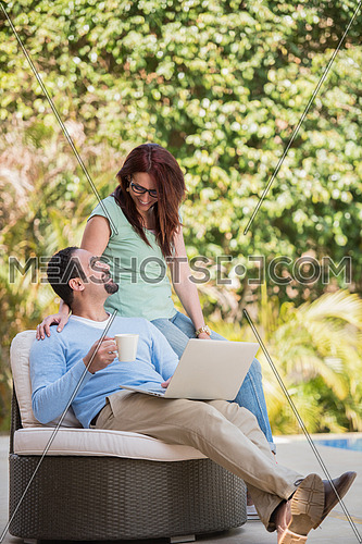 Young Middle Eastern couple enjoying your morning coffee in the garden sunny summer morning