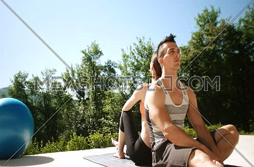 Couple Doing Stretching Exercises Together in front of luxury villa