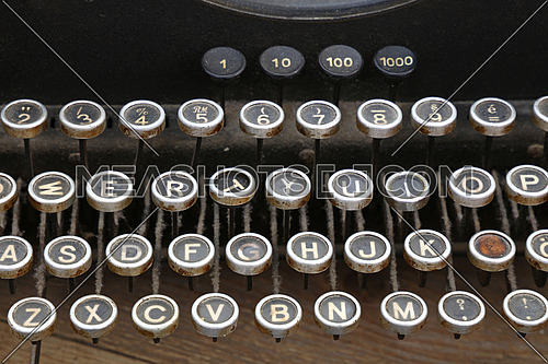 Latinic keyboard of old vintage antique typewriter with round buttons close up, high angle view, personal perspective