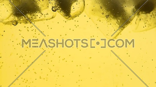 Extreme close up sparkling wine, soda water or lemonade with ice cubes in glass, low angle side view, slow motion