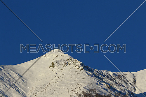 Mountain peaks and valley covered in snow with clear blue skies