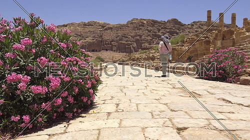 Slow pan as tourist walks on the roadway inside Petra