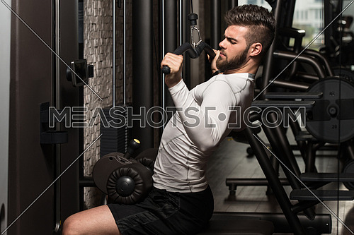 Young Man Doing Heavy Weight Exercise For Back In Gym