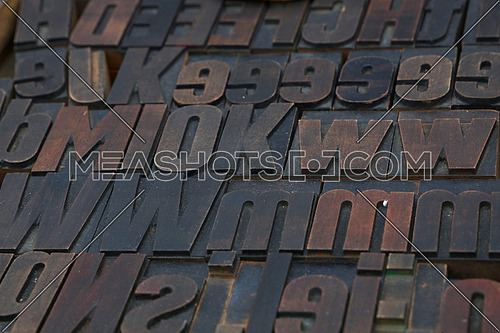 Old dark wooden vintage antique offset typography letterpress printing blocks grunge dirty with paint, mixed alphabet, close up, high angle view