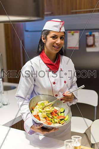 young female middle east chef preparing a salad in the kitchen