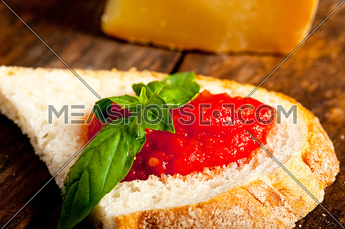 Italian fresh tomato and basil bruschetta with pecorino cheese over old wood