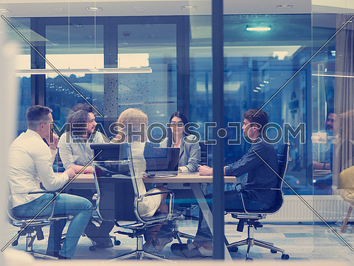 Group of a young business people discussing business plan at modern startup late night office building