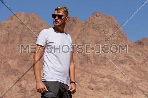 Long shot for a male tourist exploring Sinai Mountain for wadi Freij at day.