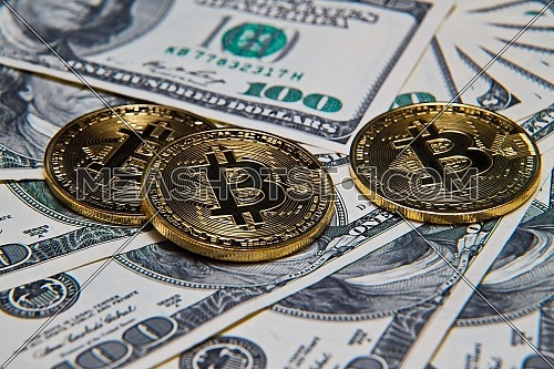 Bitcoins and dollars with calculator in background