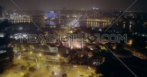 Aerial shot flying backward Cairo opera house showing the river Nile and Kasr AL Nile Bridge at night