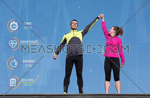 Happy fitness runner couple with arms raised up in winning gesture expression