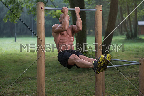 Young Athlete Working Out Biceps In An Outdoor Gym - Doing Street Workout Exercises