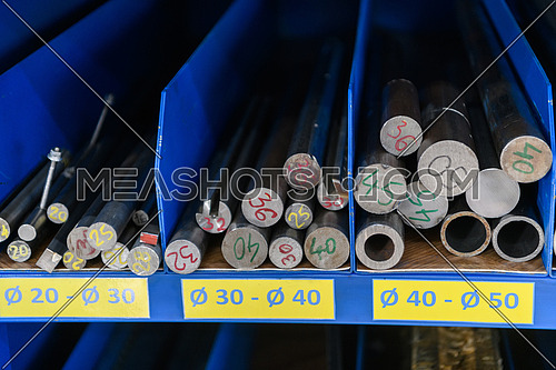 pipes, metal pieces, and various metal parts for a CNC machine standing on a shelf. High quality photo