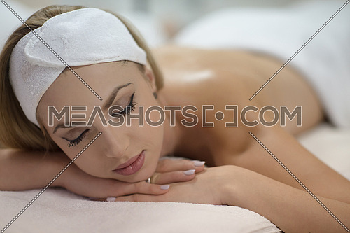 beautiful young woman getting back massage in spa and wellness salon