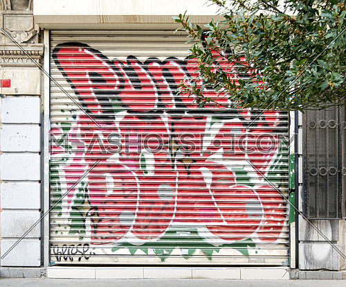 Istanbul, Turkey - April 18, 2017:  Closed shop exterior with metal door covered with colorful graffiti near Istiklal Street, Istanbul, Turkey