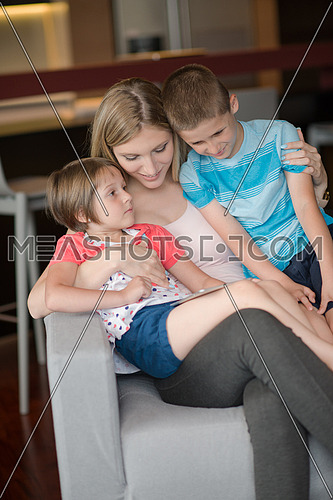 Happy Family Lying Down On The Sofa And Using Tablet
