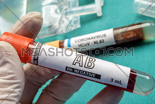 Nurse holds plasma Rh negative vial to transfuse patient covid19, conceptual image