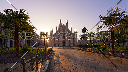 Duomo square with new exotic palms tree , Milan gothic cathedral at sunrise,Europe.