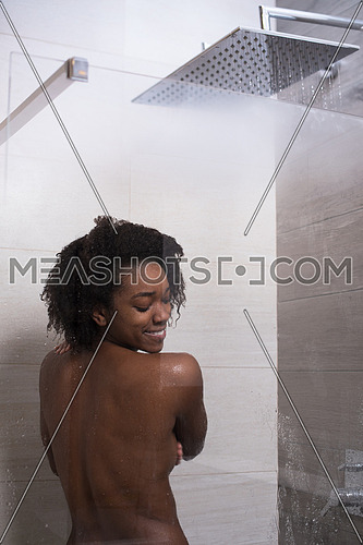Woman in the shower,beautiful black young female showering under refreshing water, healthy lifestyle, enjoying time in luxury spa resort
