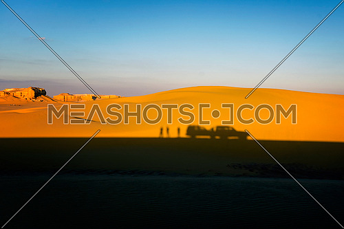 Desert Safari 4x4 white car and tourists silhouette shadow in Nature Reserve Desert Dunes landscape with blue sky , Arial View Fayoum , Egypt